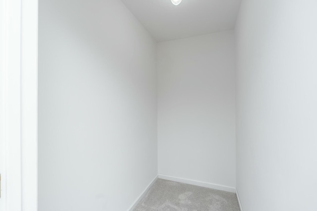 unfurnished room with baseboards and light colored carpet