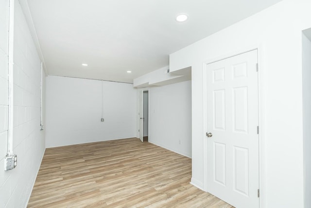 basement featuring recessed lighting, light wood-style flooring, and concrete block wall