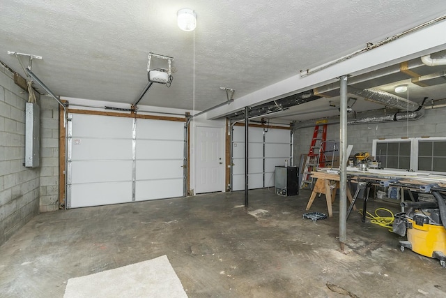 garage with electric panel, concrete block wall, and a garage door opener