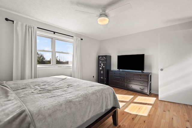 bedroom with ceiling fan, a textured ceiling, and hardwood / wood-style flooring