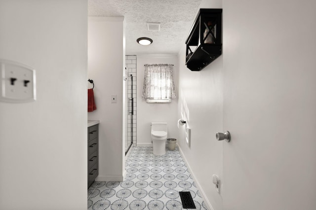 bathroom with a textured ceiling, toilet, visible vents, baseboards, and a shower