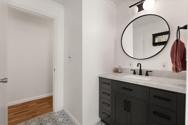 bathroom with baseboards, wood finished floors, and vanity