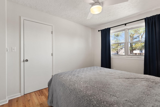 bedroom with ceiling fan, a textured ceiling, and light wood finished floors