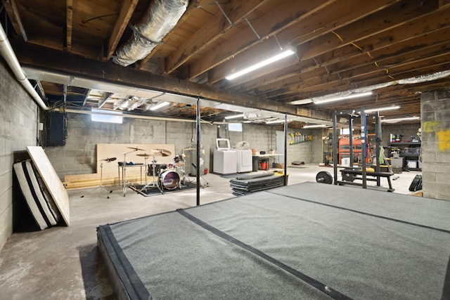 basement featuring water heater, separate washer and dryer, and electric panel