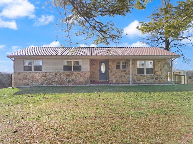 ranch-style home with a front yard, stone siding, and metal roof