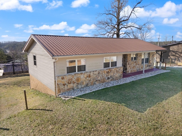 exterior space with stone siding, metal roof, and a front lawn