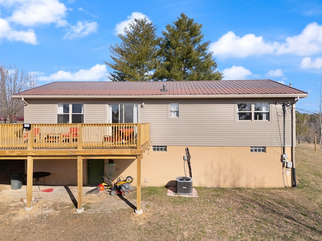 rear view of house with a deck, metal roof, and a yard