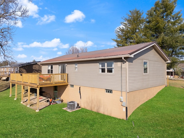 rear view of house featuring cooling unit, metal roof, a yard, and a wooden deck