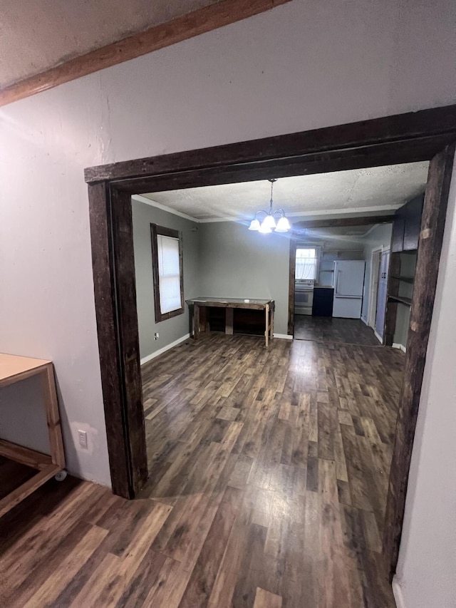 interior space featuring beamed ceiling, wood finished floors, and baseboards