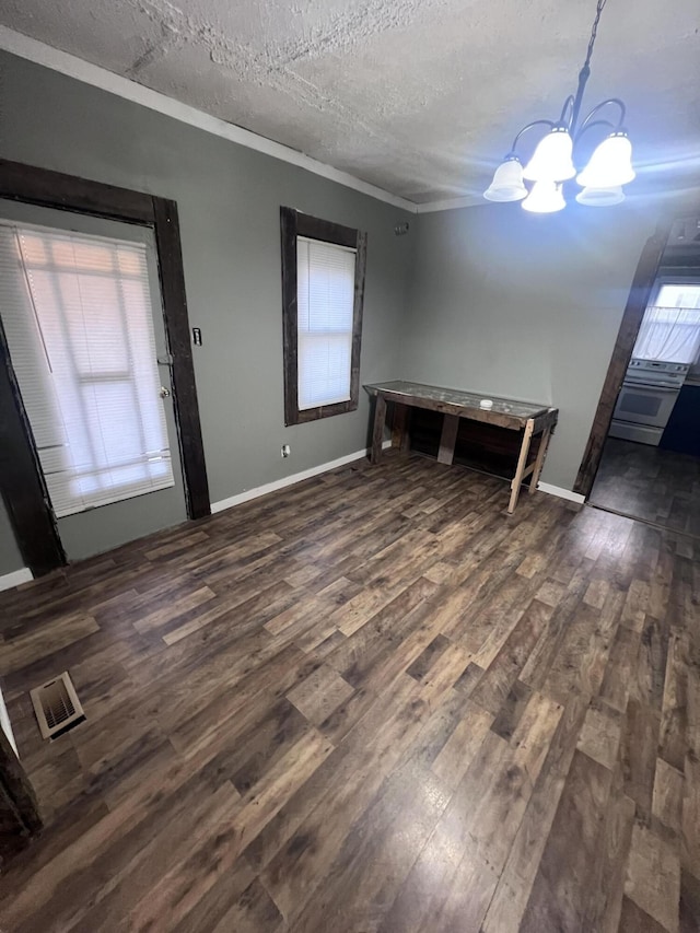 unfurnished dining area with a textured ceiling, visible vents, baseboards, dark wood-style floors, and an inviting chandelier