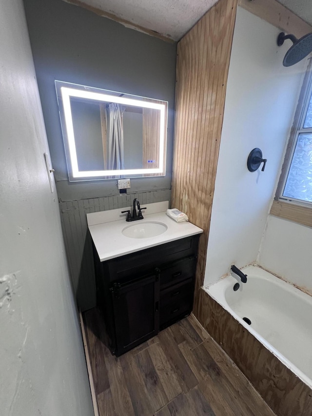 bathroom featuring bathtub / shower combination, wood finished floors, and vanity