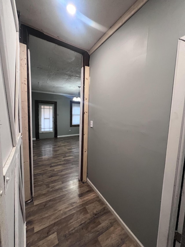 hallway featuring dark wood-style floors and baseboards