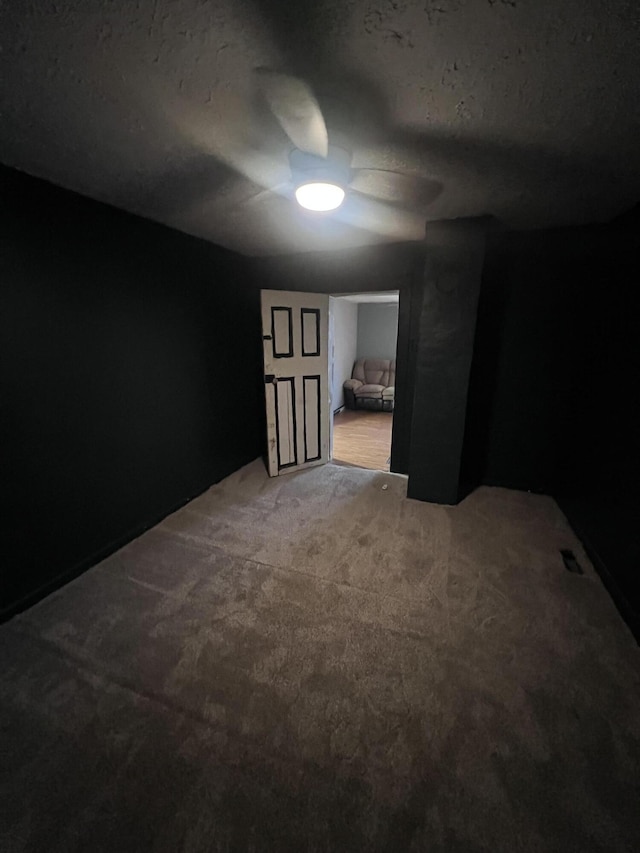 below grade area with a textured ceiling and carpet