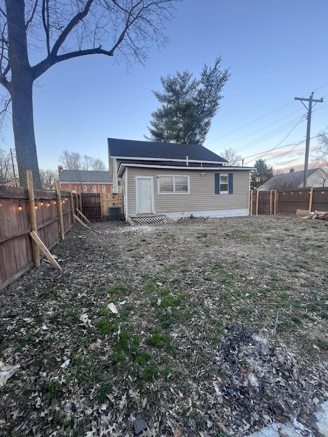 back of property featuring central AC unit and a fenced backyard