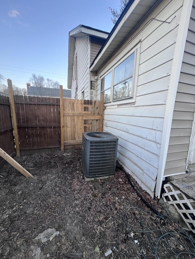 view of side of home with fence and cooling unit