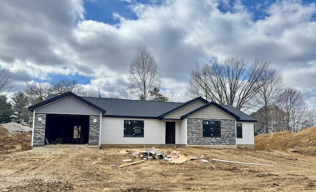 view of front of house with a garage, stone siding, and a shingled roof