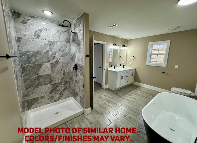 bathroom featuring wood tiled floor, visible vents, tiled shower, and vanity