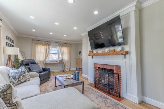 living area featuring baseboards, crown molding, light wood-style floors, a fireplace, and recessed lighting