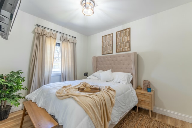 bedroom with baseboards and wood finished floors