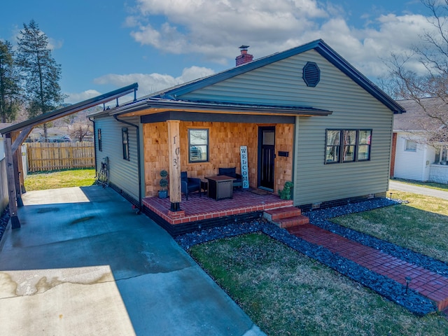 view of front of home with a chimney, a front yard, and fence