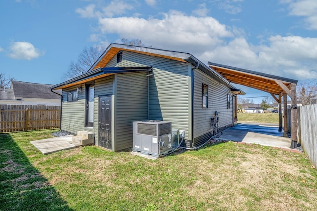 view of property exterior with central AC, a lawn, and fence