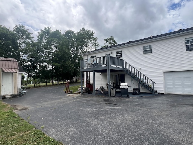 view of car parking with stairs and aphalt driveway