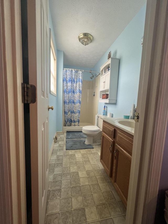 full bath featuring shower / tub combo with curtain, a textured ceiling, toilet, and vanity