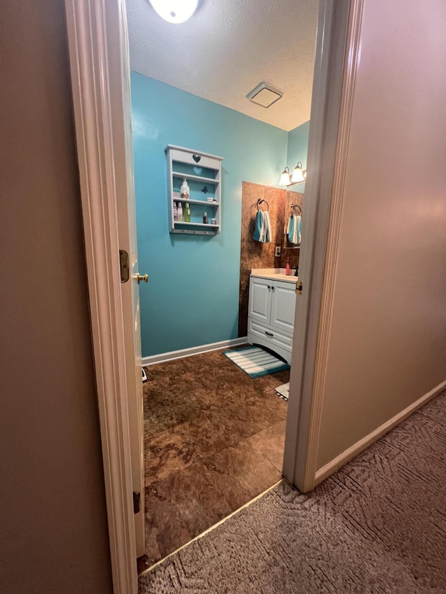 bathroom featuring vanity, baseboards, and a textured ceiling