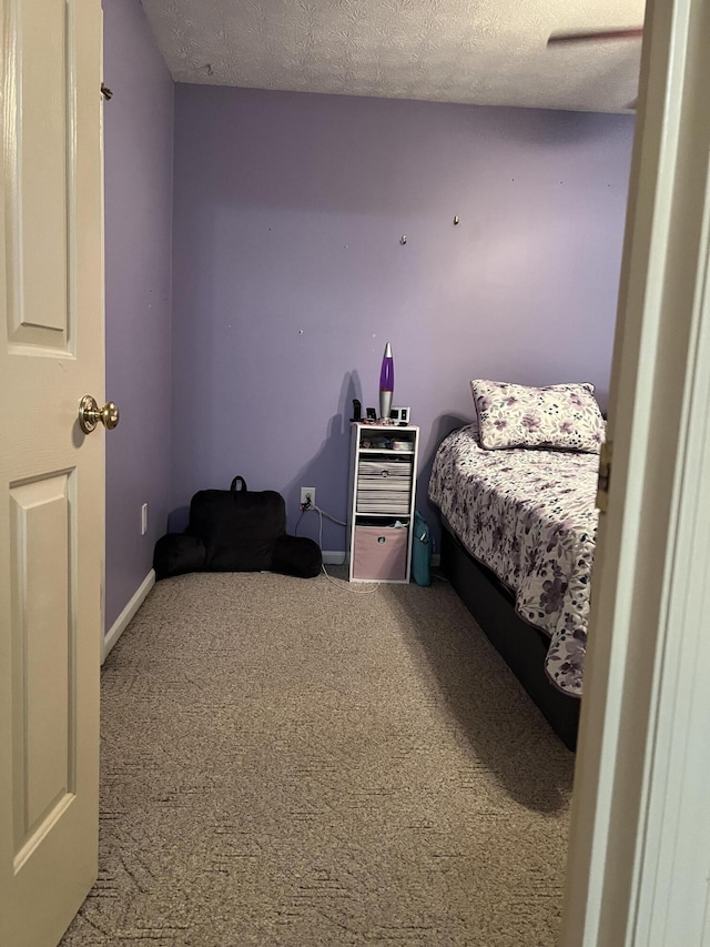 bedroom featuring a textured ceiling and carpet floors