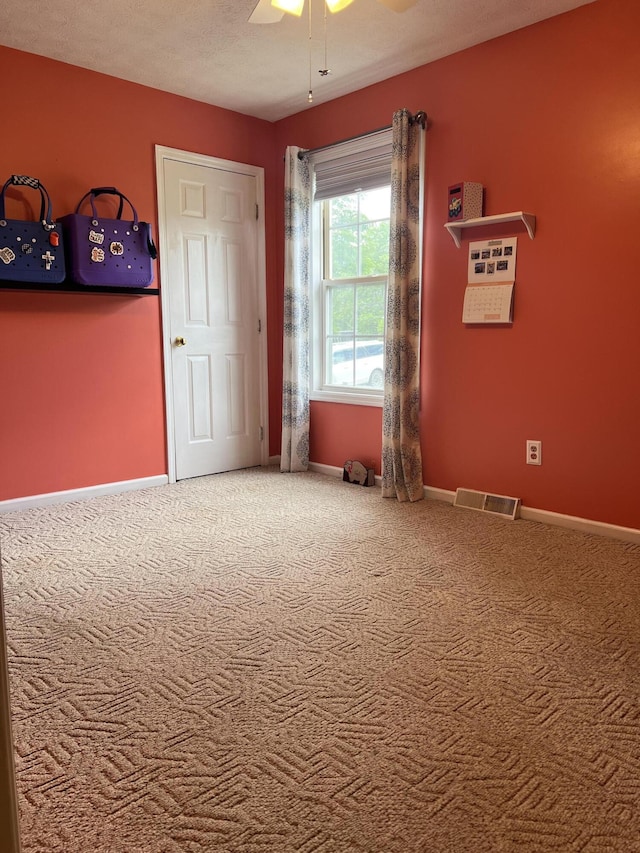 unfurnished bedroom featuring ceiling fan, carpet flooring, visible vents, and baseboards