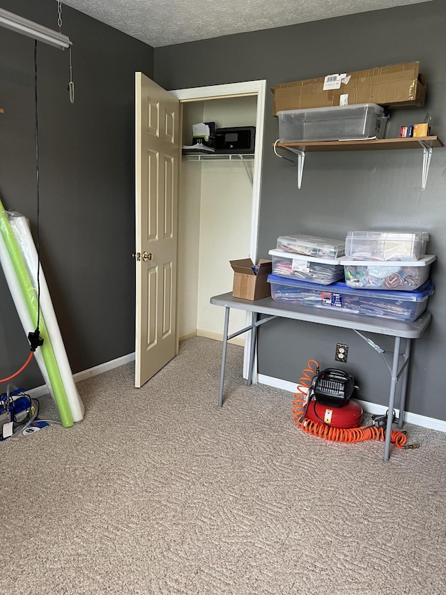 home office featuring carpet floors, a textured ceiling, and baseboards