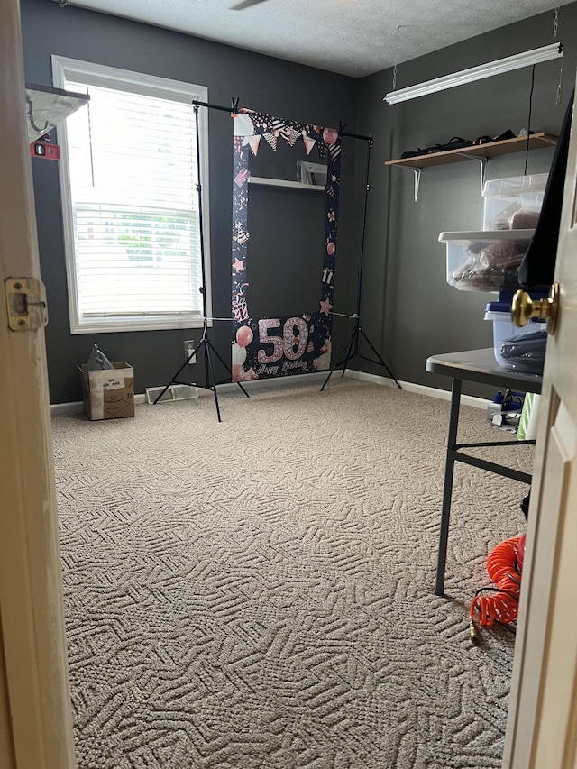 carpeted bedroom with baseboards and a textured ceiling