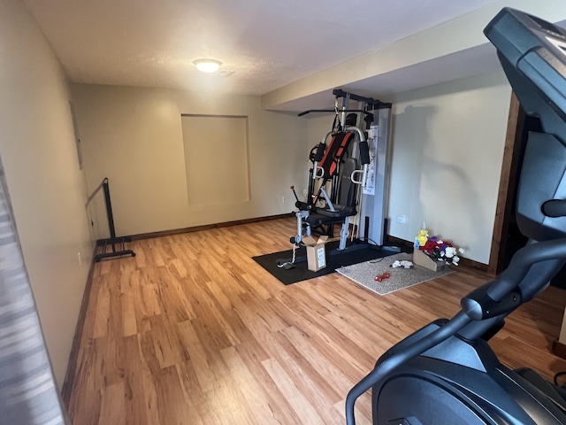 exercise area featuring baseboards and wood finished floors