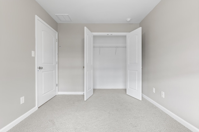 unfurnished bedroom with carpet, visible vents, baseboards, and a closet