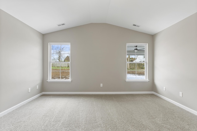 unfurnished room with baseboards, visible vents, vaulted ceiling, and carpet flooring