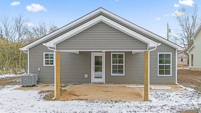 snow covered property with central AC