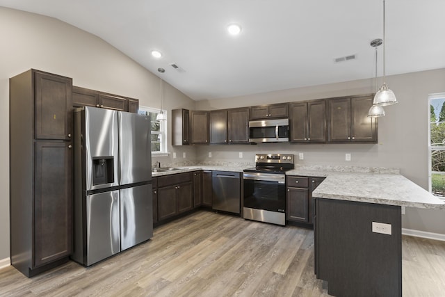 kitchen featuring visible vents, appliances with stainless steel finishes, vaulted ceiling, dark brown cabinetry, and a peninsula