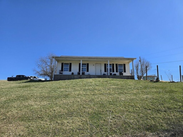 view of front of home with covered porch and a front lawn