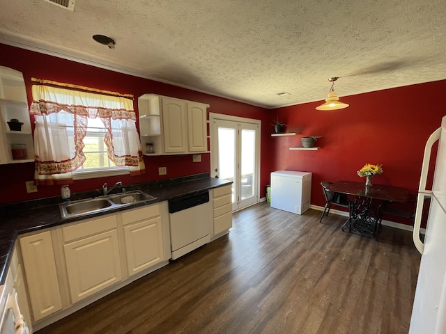 kitchen with white appliances, dark countertops, dark wood-style floors, open shelves, and a sink