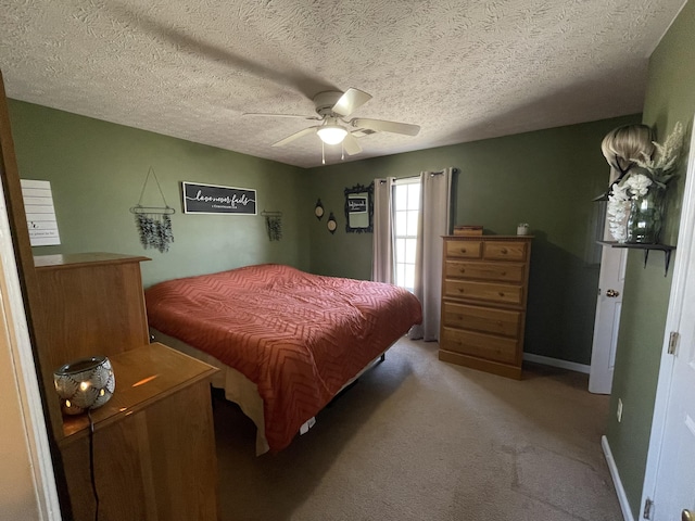 carpeted bedroom featuring ceiling fan, baseboards, and a textured ceiling