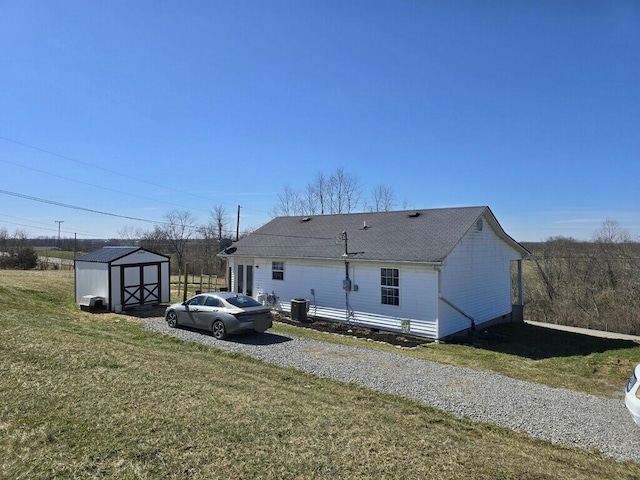 view of home's exterior featuring an outbuilding, central air condition unit, a lawn, crawl space, and a shed