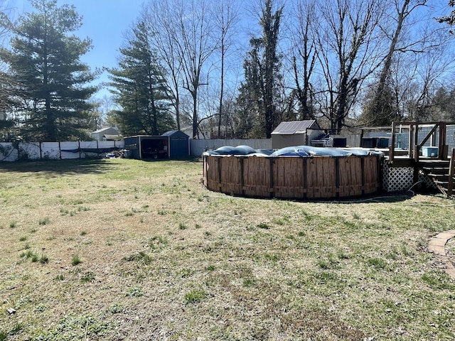 view of yard with a storage shed, an outdoor structure, a fenced backyard, and a fenced in pool