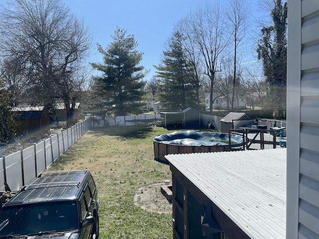 view of yard with a fenced backyard and an outbuilding