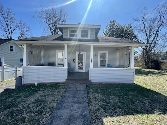 bungalow-style home with a porch, a front yard, and fence