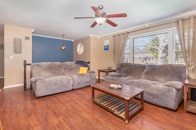 living room featuring a ceiling fan, wood finished floors, baseboards, and ornamental molding