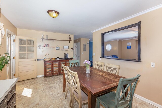 dining area featuring baseboards, a healthy amount of sunlight, and crown molding