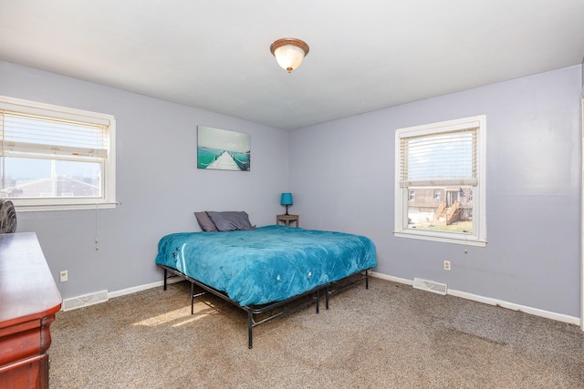 carpeted bedroom with visible vents and baseboards