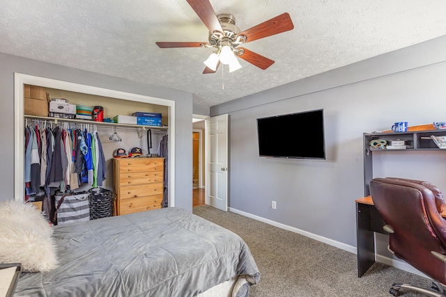 carpeted bedroom with a closet, ceiling fan, a textured ceiling, and baseboards