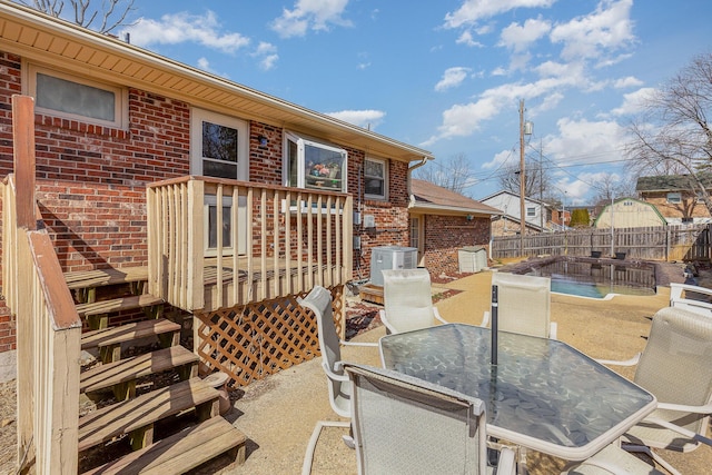 view of patio featuring stairway, outdoor dining area, a fenced backyard, central AC, and a deck