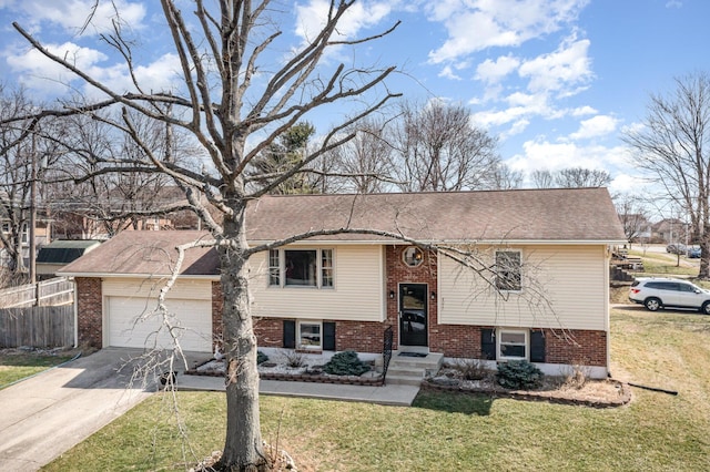 bi-level home featuring brick siding, fence, concrete driveway, a front yard, and an attached garage